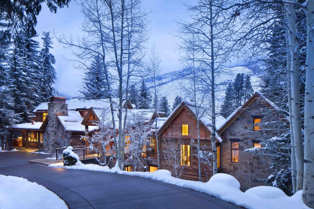 Renovated home with large windows, stone and wood exterior, snowy setting in Vail Valley, Colorado