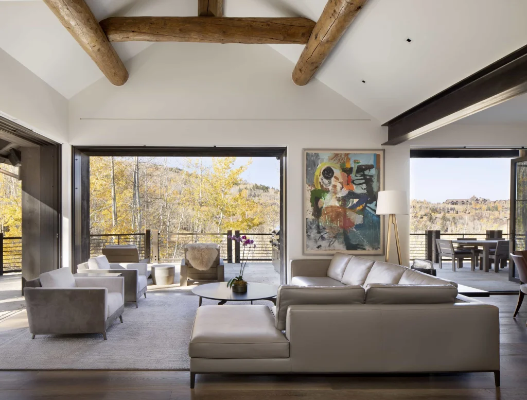 Modern interior of a log home with large windows, exposed beams, in Vail Valley, Colorado.