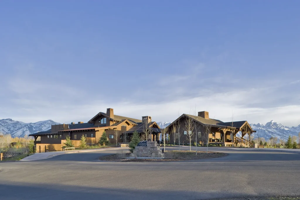 The Jackson Hole Golf & Tennis Club, featuring a timber-frame clubhouse with Teton mountain views