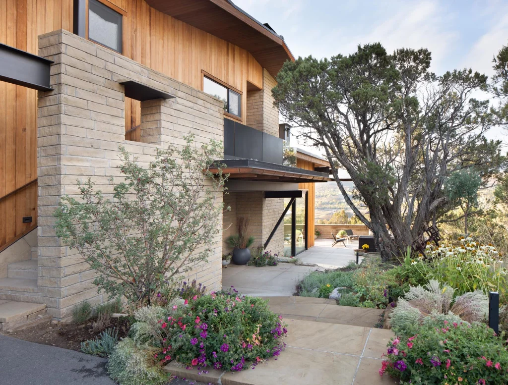 Minimalist home with wood and stone exterior, nestled on a mountainside in Vail Valley, Colorado.
