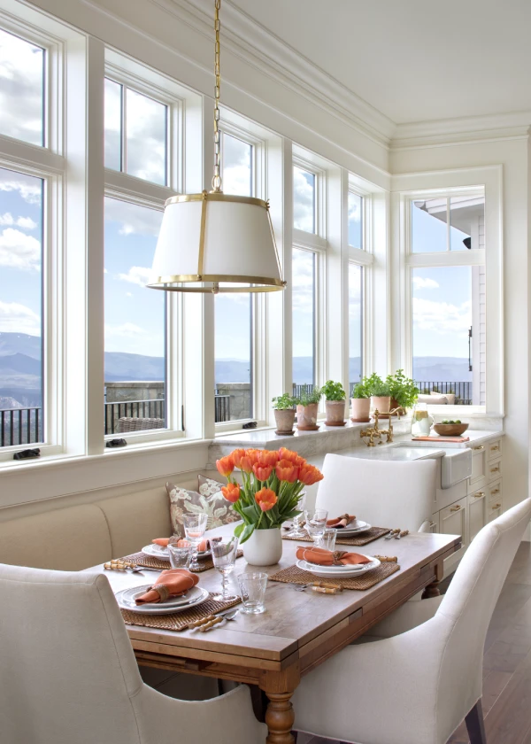Bright dining area with mountain views, featuring a cozy nook, rustic table, and elegant decor
