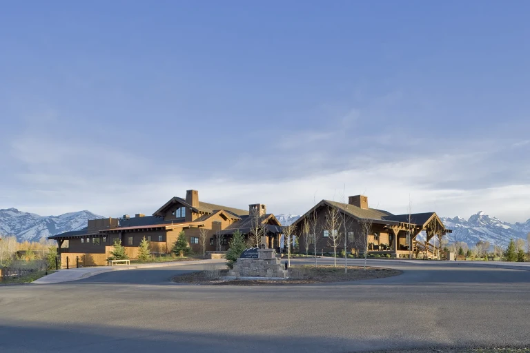 The Jackson Hole Golf & Tennis Club, featuring a timber-frame clubhouse with Teton mountain views
